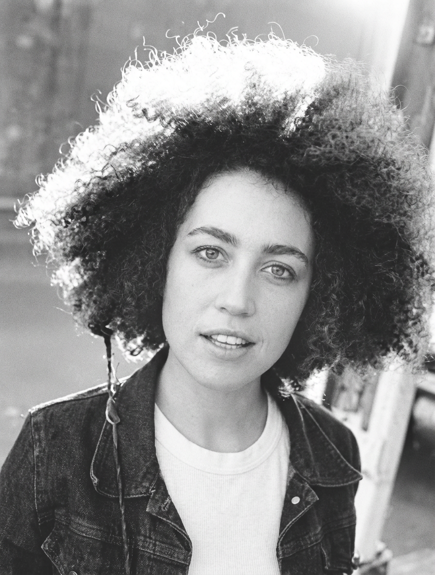 Backlit portrait of model with voluminous Jewfro and soft sunlight rim light generated by blondefilter.net