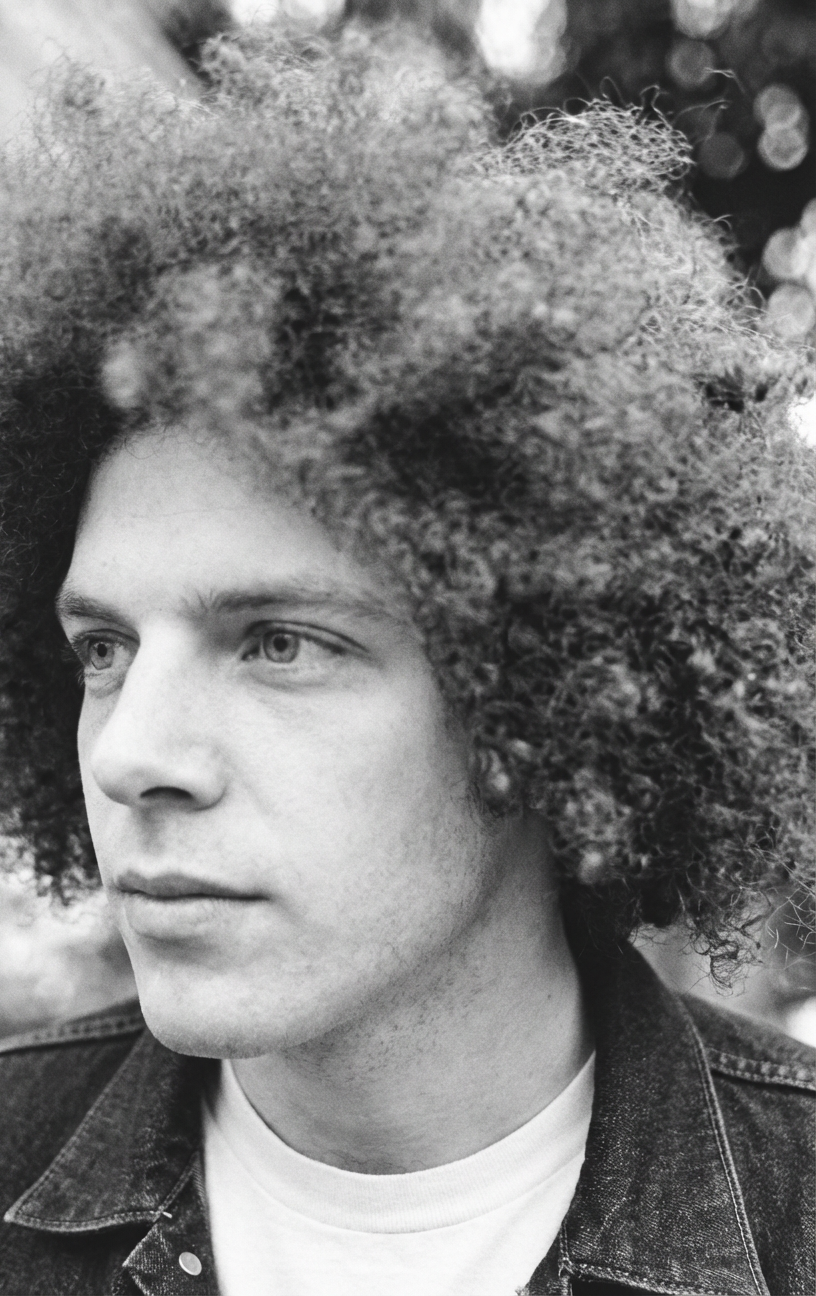 Black and white side profile of man with textured Jewfro halo and denim jacket generated by blondefilter.net