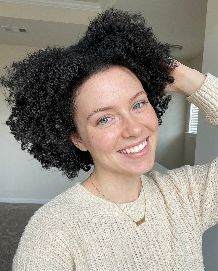 Smiling model with voluminous curly hair lifted into a loose middle part generated by blondefilter.net